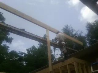 Carpenter setting a ridge beam over a new addition frame — Ice Dam Removal by Roofing Brothers in Tyrone