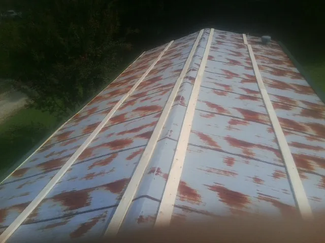 Rusted metal roof panels with new wood purlins before replacement — Storm Damage Roof Repair in Tyrone by Roofing Brothers