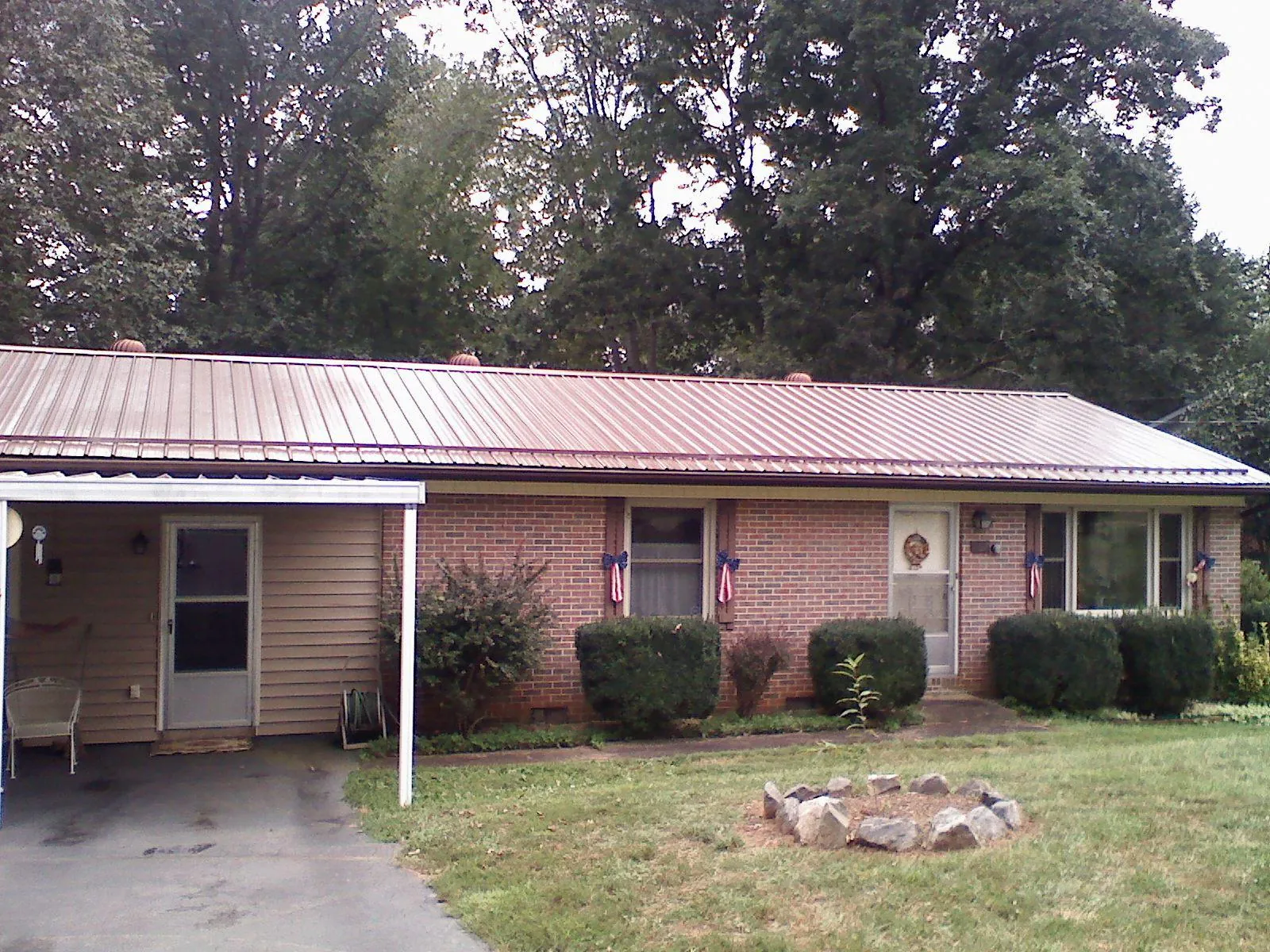 Bronze metal roof and carport on a brick ranch home — Roof Repair work by our crew in Tyrone